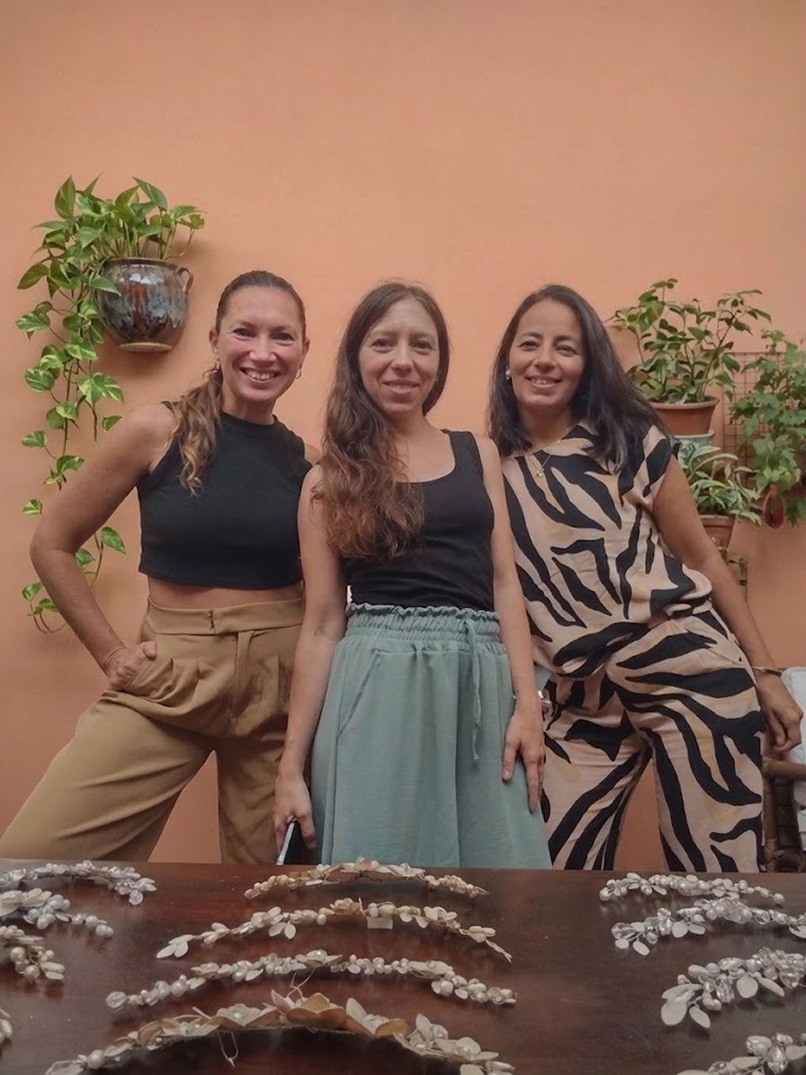 Equipo de Trihada junto a una mesa con tiaras y accesorios exhibidos en una feria